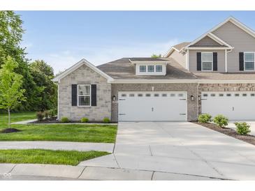 New townhome features a two-car garage, brick facade, and manicured lawn at 6465 Wasco Dr, Whitestown, IN 46075