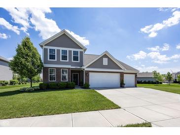 Charming two-story home with a well-manicured lawn, brick accents, and a three-car garage at 16419 Connolly Dr, Westfield, IN 46074