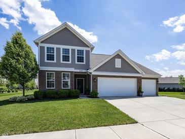 Charming two-story home featuring a brick facade, well-manicured lawn, and a three-car garage at 16419 Connolly Dr, Westfield, IN 46074