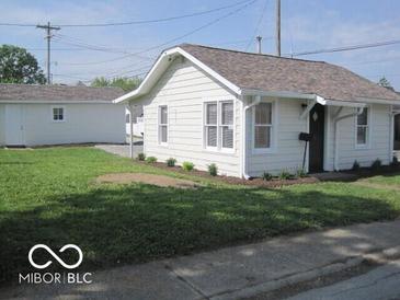 Quaint single-Gathering home featuring clean white siding, a well-kept lawn, and a detached garage at 201 W Essex St, Lebanon, IN 46052