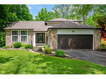 Charming home featuring stone accents, a well-maintained lawn, and a two-car garage at 3230 Amherst St, Indianapolis, IN 46268