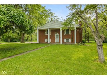 Charming brick home featuring a spacious lawn and classic architectural details at 502 S Harrison St, Alexandria, IN 46001