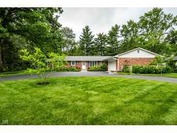 Beautiful brick home featuring a lush green lawn and a circular driveway, perfect for curb appeal at 5415 Kilmer Ln, Indianapolis, IN 46250
