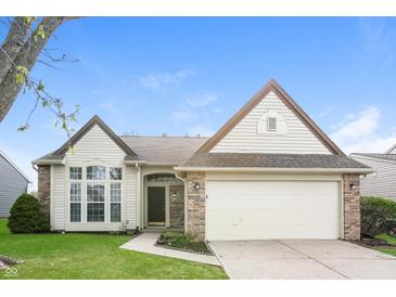 Charming home featuring a manicured lawn, brick accents, attached two-car garage and manicured landscaping at 6121 Jester Ct, Indianapolis, IN 46254