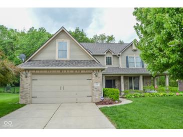 Charming two-story home features a brick-accented garage, manicured lawn, and welcoming curb appeal at 7322 Stones River Dr, Indianapolis, IN 46259