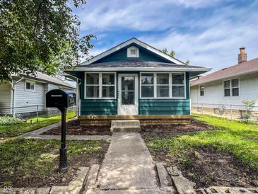Charming blue home featuring a quaint front porch and lovely curb appeal at 946 N Somerset Ave, Indianapolis, IN 46222