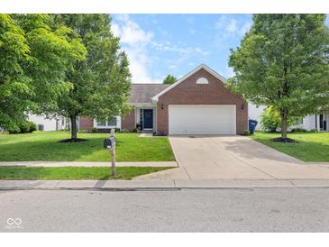 Charming brick home with a two-car garage, a well-manicured lawn, and mature trees in a quiet neighborhood at 11209 Black Gold Dr, Noblesville, IN 46060