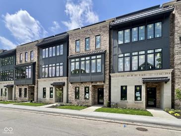 Modern townhome exterior featuring a brick facade, black framed windows, and covered entryways at 120 First Ne Ave, Carmel, IN 46032