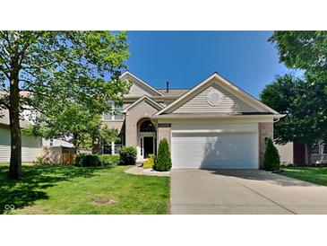 Charming two-story home with a well-manicured lawn and attached two-car garage, complemented by mature trees at 12878 Ari Ln, Fishers, IN 46037