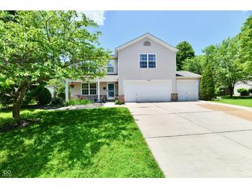 Inviting two-story home with a well-manicured lawn, charming landscaping, and a three-car garage at 16857 Palmetto Way, Noblesville, IN 46062