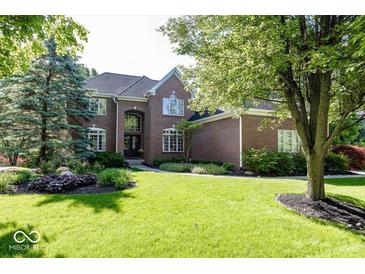 Well-maintained brick home with lush landscaping, mature trees, and a sprawling green lawn at 21218 Carlton Ct, Noblesville, IN 46062