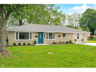 Charming one-story home featuring a blue front door and well-maintained front lawn at 3027 Griffa Ave, Columbus, IN 47203
