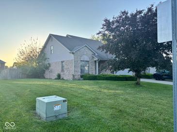 Charming single-Gathering home featuring a well-manicured lawn, brick facade, and mature tree at 3037 Ash Way, Lapel, IN 46051