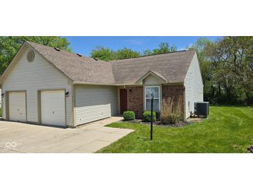 Charming home with a brick facade, siding, well-manicured lawn, and attached garage at 413 Woodberry Dr, Danville, IN 46122