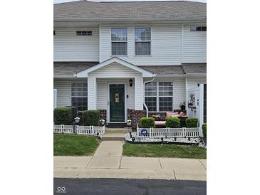 Charming two-story townhouse with well-maintained lawn, landscaping, and front porch decor at 4962 Potomac Square Pl, Indianapolis, IN 46268