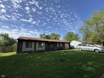 Charming single-story home featuring a well-maintained lawn and a welcoming facade on a sunny day at 5601 Milhouse Rd, Indianapolis, IN 46221