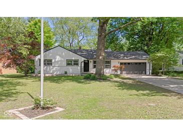 Charming single-story home featuring a well-maintained lawn and beautiful mature trees at 5843 N Oakland Ave, Indianapolis, IN 46220