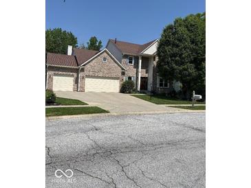 Charming two-story brick home featuring a two-car garage and well-manicured lawn at 8130 Winterset Cir, Indianapolis, IN 46214