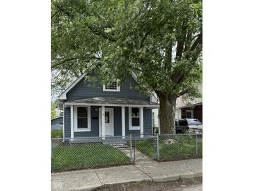 Charming single-story home with a fenced yard and a mature tree at 23 S Holmes Ave, Indianapolis, IN 46222