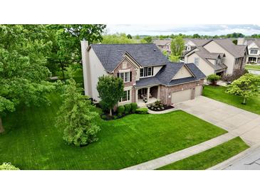 Beautiful two-story home with a well-manicured lawn, lush landscaping and charming brick and vinyl facade at 3251 Amber Way, Bargersville, IN 46106