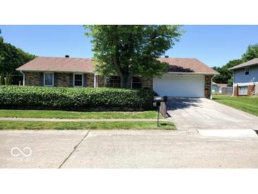 Charming single-story brick home featuring a well-manicured lawn and an attached two-car garage with a concrete driveway at 3702 Candy Cane Dr, Indianapolis, IN 46227