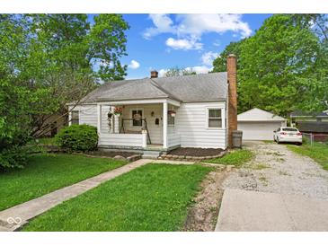 Charming single-story home with a covered front porch, lovely landscaping, and a detached garage at 376 S Arlington Ave, Indianapolis, IN 46219