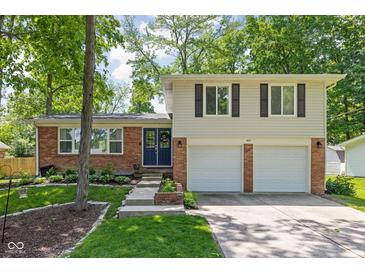 Charming home featuring a brick facade, attached two-car garage, and a well-maintained front yard with mature trees at 469 Ash Dr, Carmel, IN 46032