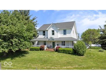 Inviting two-story home with a charming wrap-around porch, manicured lawn, and mature landscaping at 5480 E County Rd 800 N, Brownsburg, IN 46112