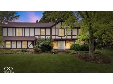 Charming two-story home with Tudor-style accents, lush lawn, and mature trees at 659 Carson Ct, Carmel, IN 46033