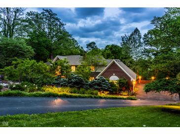 Charming two-story brick home with mature landscaping, driveway, and exterior lighting at 8209 Beech Knoll, Indianapolis, IN 46256