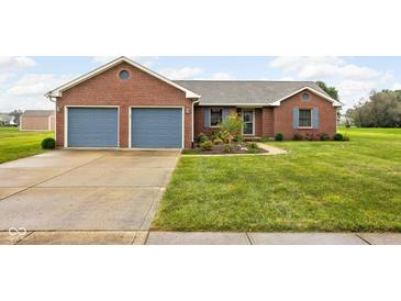 Charming brick home with a well-manicured lawn and a two-car garage and light blue shutters at 9159 E County Road 400 N, Brownsburg, IN 46112