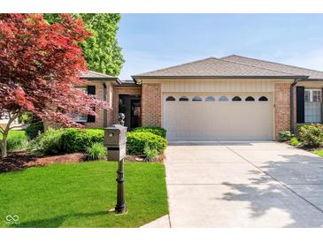Charming single-story home with brick accents, manicured lawn, and an attached two-car garage at 1045 Millwood Ct, Indianapolis, IN 46260
