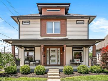 Inviting two-story home showcasing a covered front porch with seating, manicured lawn, and craftsman details at 1048 St Peter St, Indianapolis, IN 46203