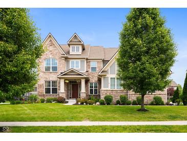 Beautiful two-story brick home with a well-manicured lawn and mature trees at 15580 Garrano Ln, Fishers, IN 46040