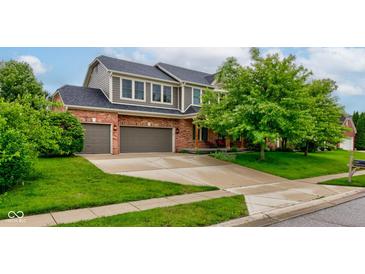 Inviting two-story home with attached two-car garage, well-manicured lawn and mature trees at 1649 Woodstock Dr, Brownsburg, IN 46112