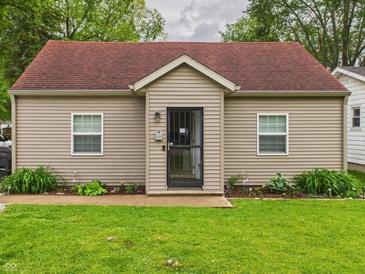 Charming single-story home with tan siding, a red roof, a well-kept lawn, and a black front door at 2353 E 10Th St, Anderson, IN 46012