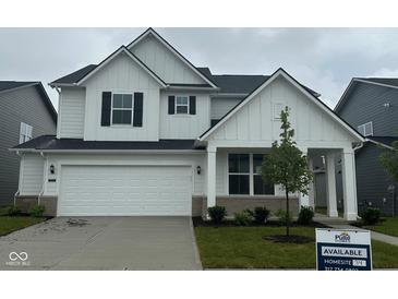 Charming two-story home with white siding, black shutters, a two car garage, and a well maintained lawn at 2705 Penn Ave, Plainfield, IN 46168
