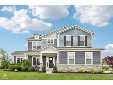Beautiful two-story home with a manicured lawn and attractive landscaping at 3316 Shelborne Woods Pkwy, Carmel, IN 46032