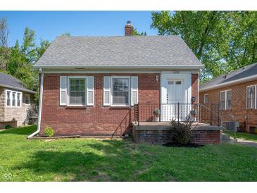 Charming brick home with a well-maintained lawn and white-trimmed windows on a sunny day at 5232 E 10Th St, Indianapolis, IN 46219