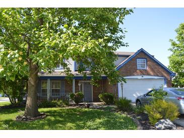Charming two-story home featuring brick accents, inviting front porch, and well-manicured lawn at 6056 Blackley Ct, Indianapolis, IN 46254