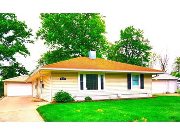 Charming single-story home with a well-maintained lawn and detached garage at 8357 Harrison Dr, Lawrence, IN 46226