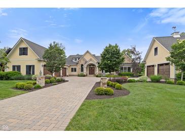 Stunning home featuring a manicured lawn, brick driveway, and charming architectural details under a clear blue sky at 860 Chatham Hills Blvd, Westfield, IN 46074