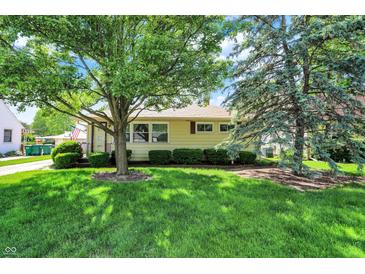 Charming single-story home with a lush green lawn and mature trees, offering great curb appeal at 2110 Fisher Ave, Speedway, IN 46224