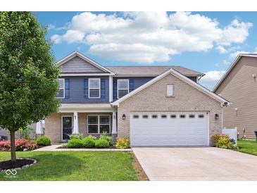 Charming two-story home featuring a brick and siding exterior, attached garage, and a well-maintained front yard at 220 Sawdust Trl, Greenfield, IN 46140