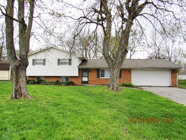 Charming two-story home with brick and siding exterior, a well-manicured lawn, and a two-car garage at 2414 Constellation Dr, Indianapolis, IN 46229