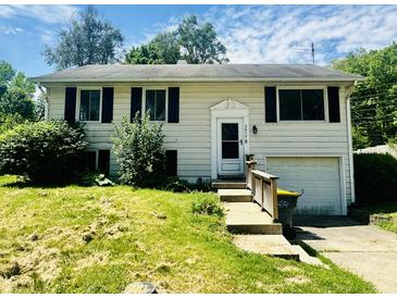 Charming home with black shutters, lush landscaping, and an attached garage at 2419 Tamarack Pl, Anderson, IN 46011