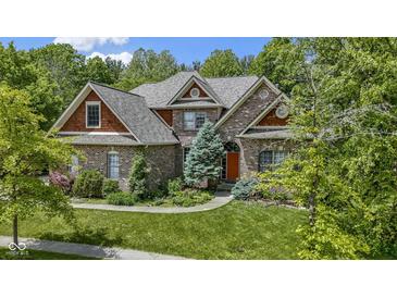 Beautiful brick home featuring a well-manicured lawn and lush landscaping at 7744 Preservation Dr, Indianapolis, IN 46278
