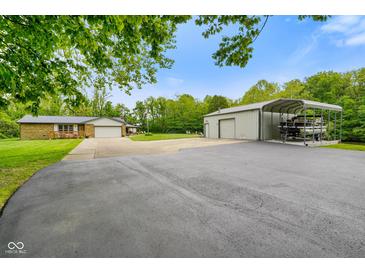 Exterior of property with long driveway, storage shed, car port, and two-car attached garage at 8000 Mcwhorter Rd, Martinsville, IN 46151