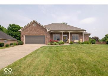 Charming brick home featuring an attached two-car garage, front porch, and well-manicured lawn at 120 Wagon Trail, Mooresville, IN 46158