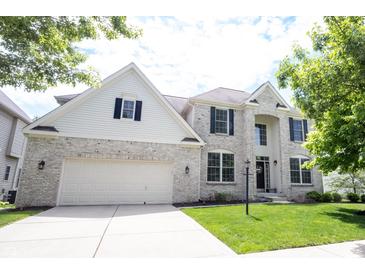 Charming two-story home featuring a brick facade, attached garage, and a well-manicured lawn, offering classic curb appeal at 12093 Ashland Dr, Fishers, IN 46037